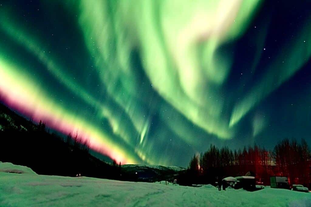 A pink and green light show of Aurora Borealis in Alaska