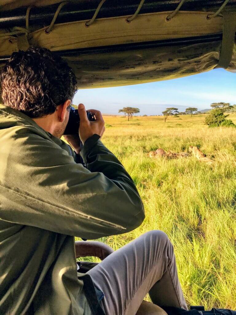 A world traveler takes photos of a pride of lions while on safari