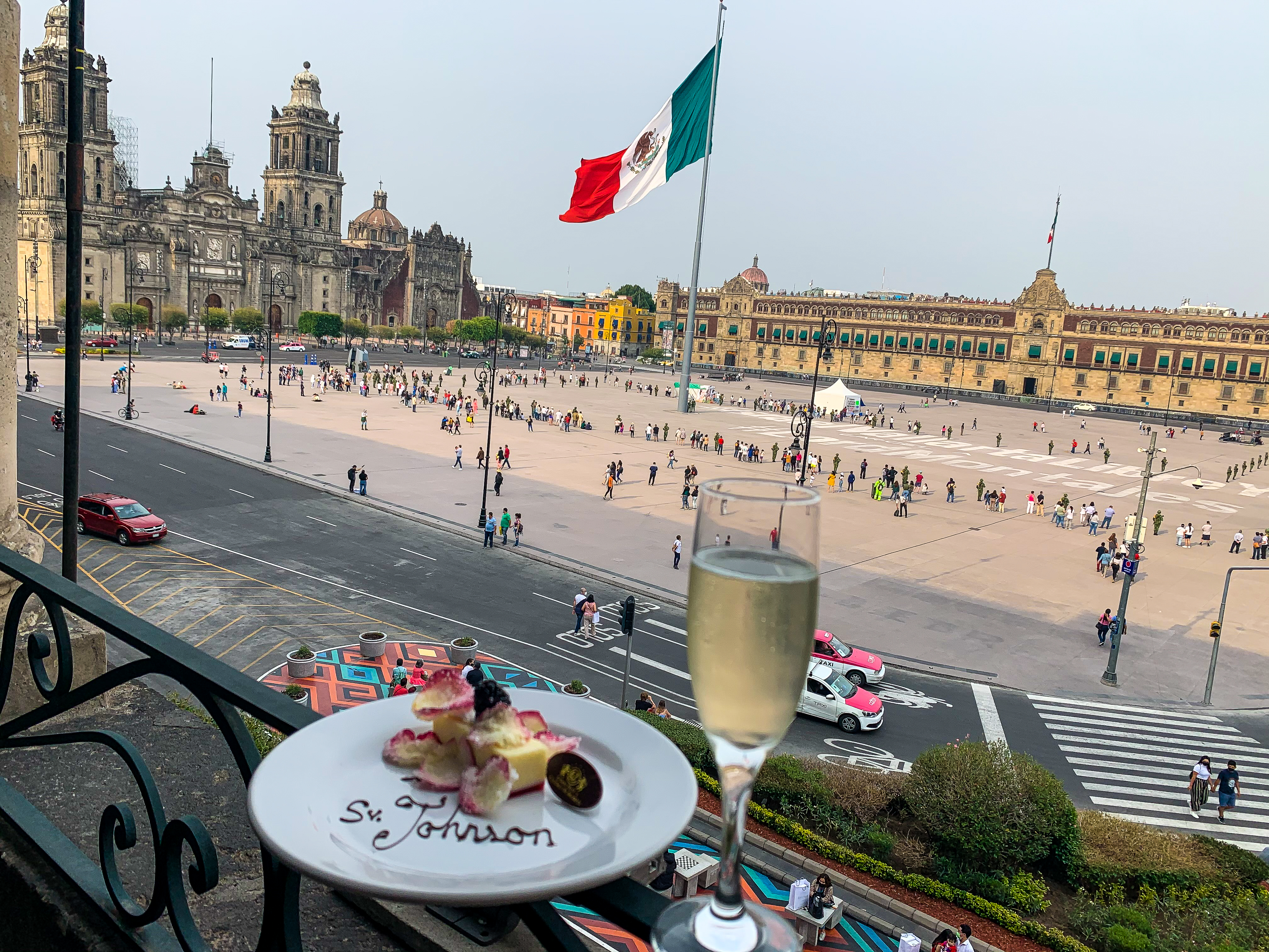 champagne and dessert in front of giant mexican flag at zocalo in mexico city 