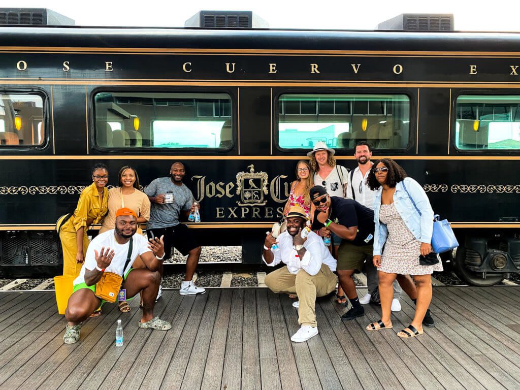 A group of people posing in front of a train entitled the Jose Cuervo Express
