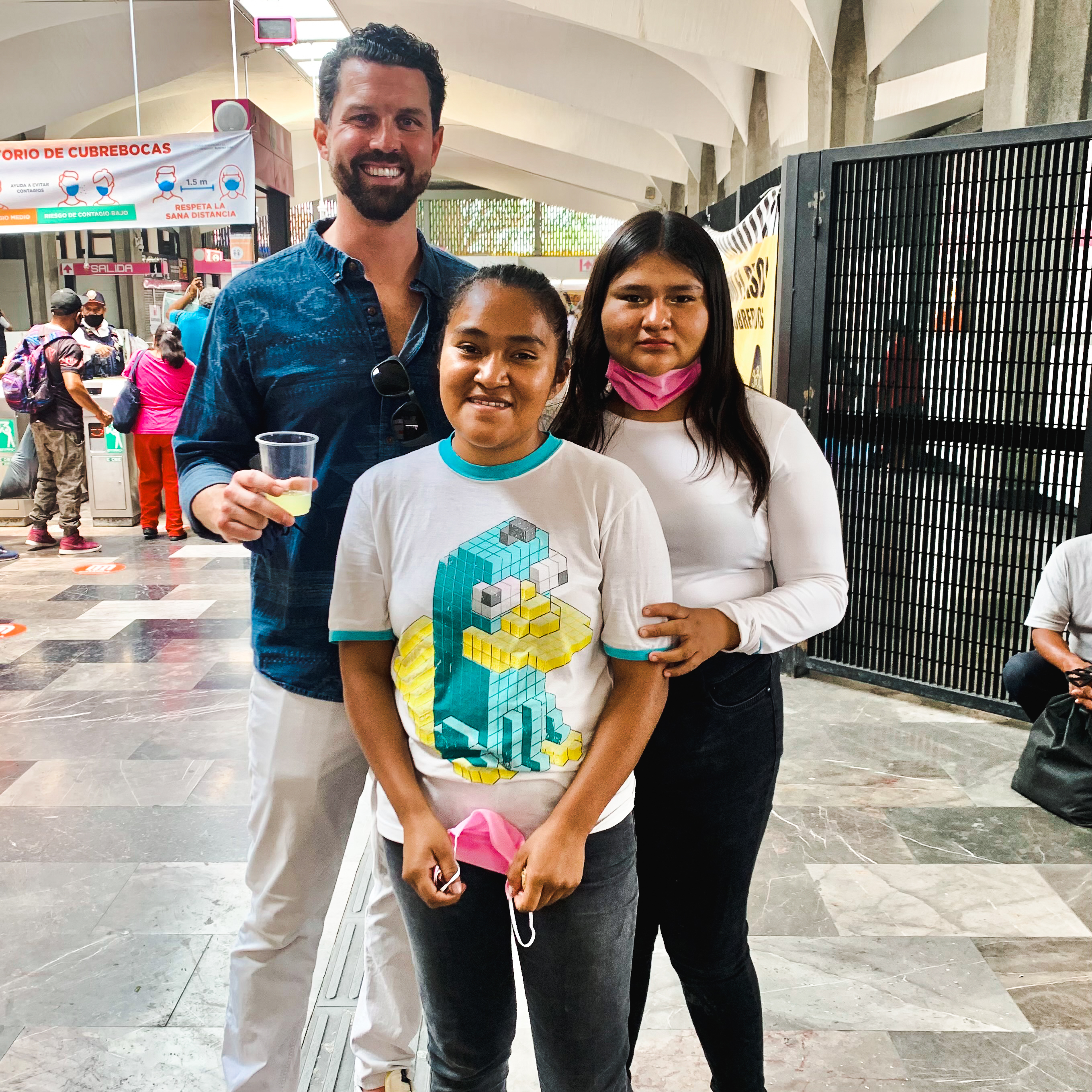 man standing with two young women in a mexico city market