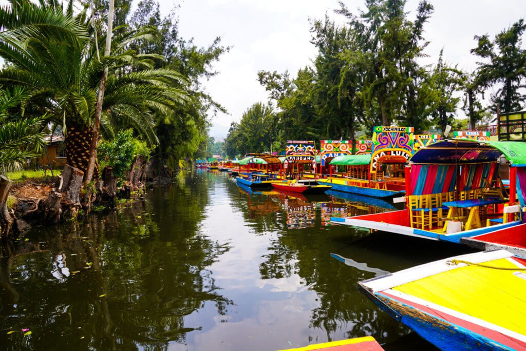 brightly colored boats in the canals of xochimilco outside mexico city