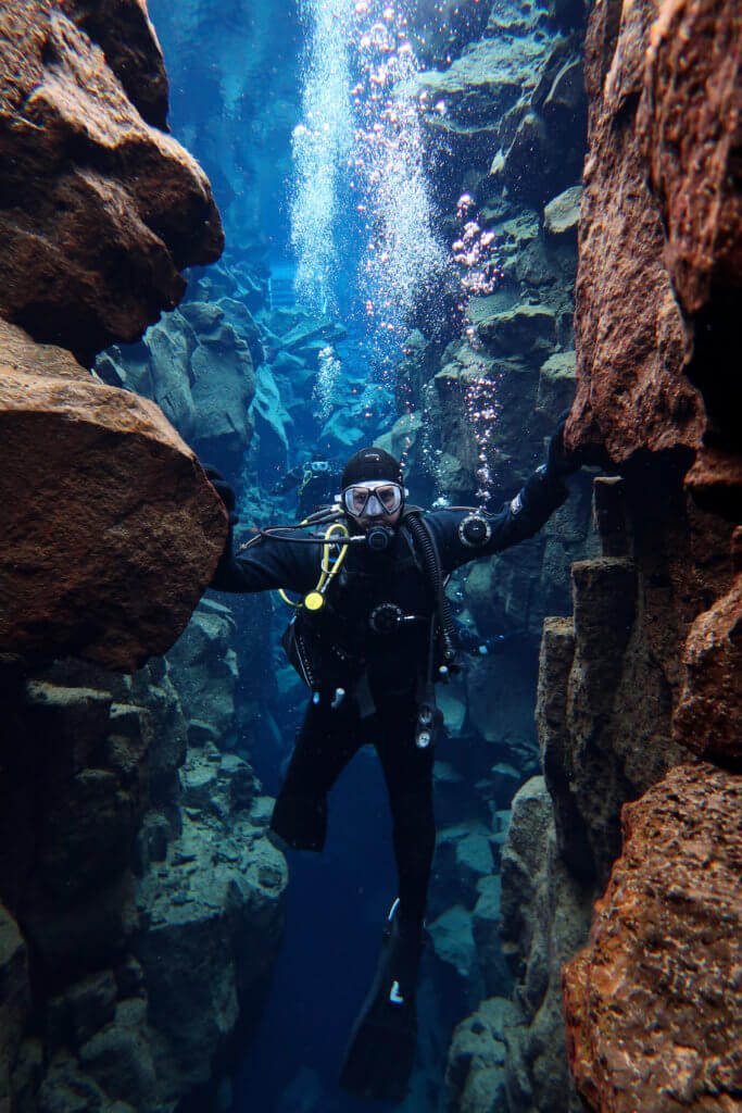 scuba diver touching two continents in iceland silfra fissure 