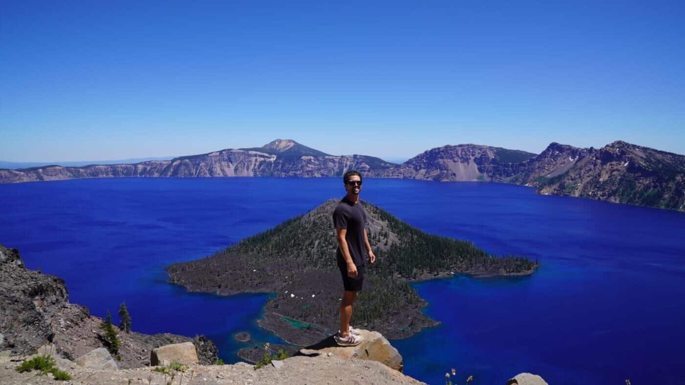 man stands at crater lake in oregon